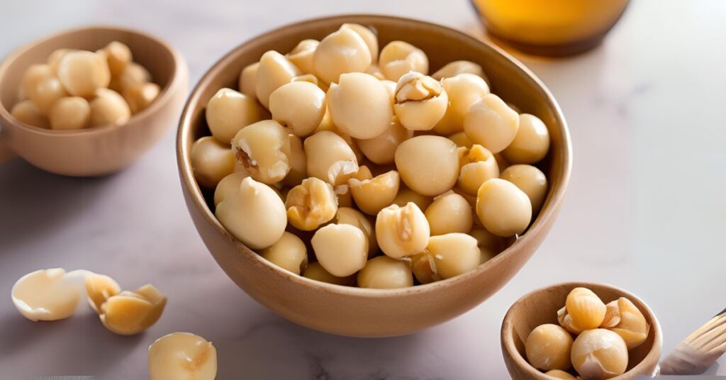 A bowl filled with whole and cracked macadamia nuts, highlighting their smooth, creamy texture and rich, golden color, showcasing their natural, wholesome appeal.