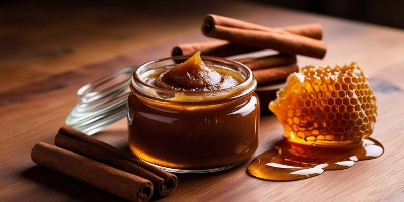 A jar of DIY cinnamon spice and honey face mask, with cinnamon sticks and honeycomb on the side for skincare