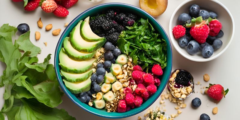 a bowl filled with high-fiber foods like greens, berries, and crushed macadamia nuts